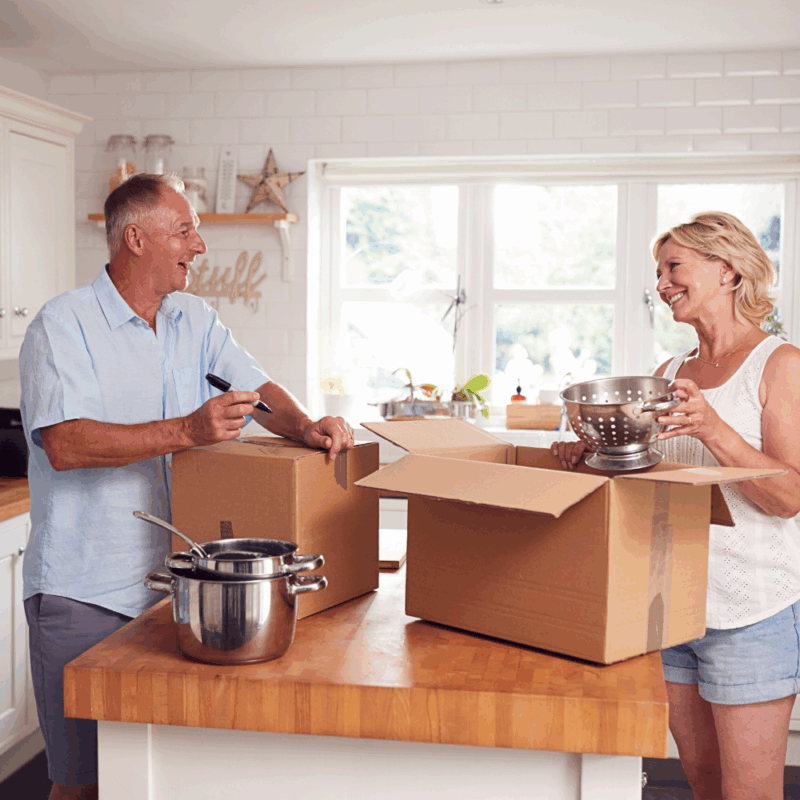 older couple packing kitchen because they know the benefits of downsizing the home